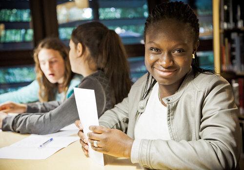 jeune fille souriante avec des papiers dans la main