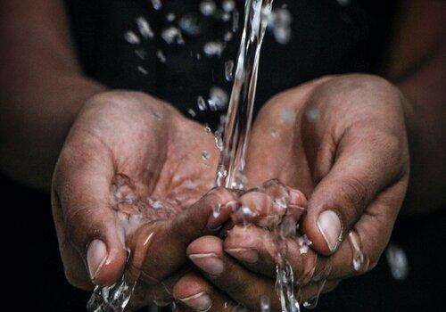 eau coule sur des mains