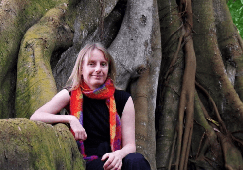 Image de l'autrice assise sur la souche d'un arbre