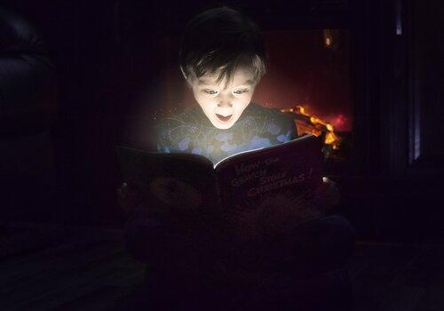 Heure du conte un enfant prend une expression émerveillée en ouvrant un livre