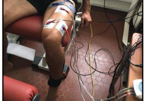 Une personne assise avec des électrodes sur la jambe .