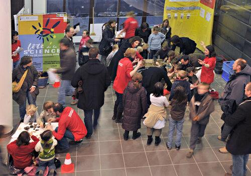 Photo du hall d'entrée de la MISHA lors d'une fête de la science. On y voit des enfants et adultes participant à des ateliers