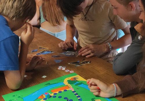 enfants jouant au jeu de plateau "Disparition au Musée"