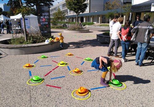 Une photo de la fête de la science 2022 avec un atelier extérieur avec des cerceaux et des chapeaux