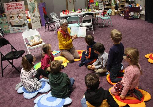 Séance de lecture à voix haute avec des enfants Lecture avec un groupe d'enfants assis en rond