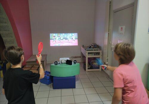 Deux enfants jouent au tennis sur un jeu vidéo Deux enfants jouent au tennis sur un jeu vidéo