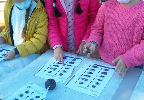 enfant tenant une météorite dans sa main
