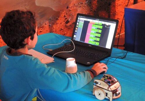 Un jeune utilisant les Boum'Bots Un jeune utilisant les Boum'Bots, robots suiveurs de ligne de Planète Sciences Occitanie