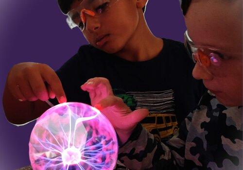 Deux enfants avec une boule à plasma