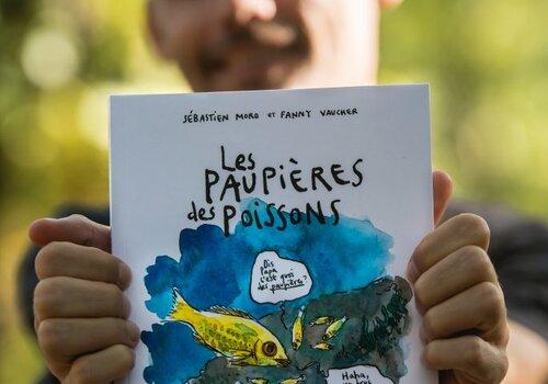 Sébastien Moro, vulgarisateur scientifique, tient dans ses mains son ouvrage "Les paupières des poissons. Une épopée scientifique et pleine d'humour à la rencontre des animaux aquatiques", BD publiée aux éditions LA PLAGE.
