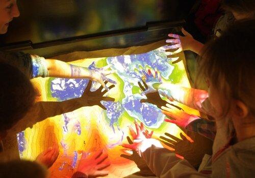 Un bac rempli de sable fin surplombé d’une caméra 3D et d’un vidéoprojecteur qui diffuse en temps réel les courbes de niveaux et des couleurs différentes