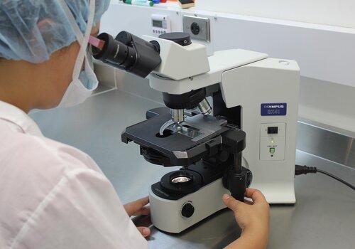 Microscope Un scientifique regarde dans un microscope