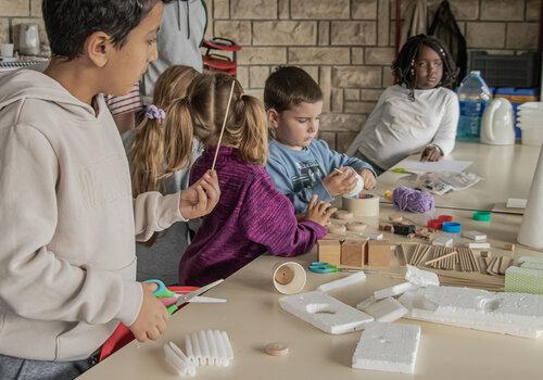 Atelier créativité technique enfants construisant un élément pour éclater un ballon