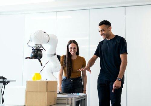 Deux personnes autour d'un bras robotisé
