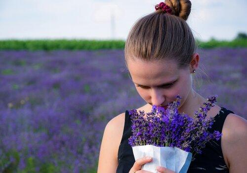 Une femme sent un pot de lavande