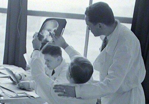 Photographie de Jean SUQUET, observation des clichés radiologiques d'un crâne, 1959 Observation des clichés radiologiques d'un crâne