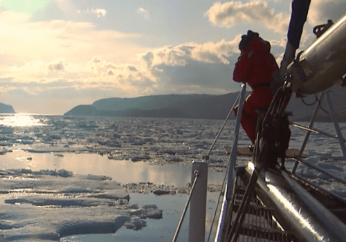 Proue d'un bâteau avec marin; vue horizon de mer glacée