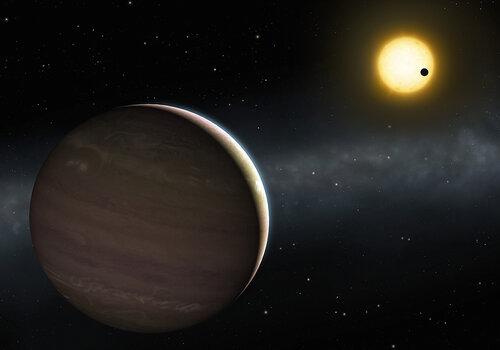 La planète WASP-148c est visible au premier plan. On voit au second plan la planète WASP-148b en transit devant l’étoile autour de laquelle les deux planètes sont en orbite.