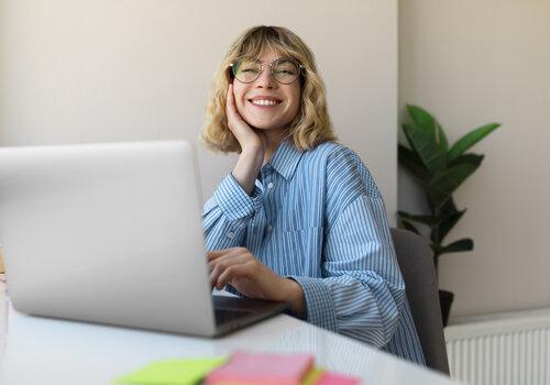 femme-souriante-tir-moyen-travaillant-sur-ordinateur-portable