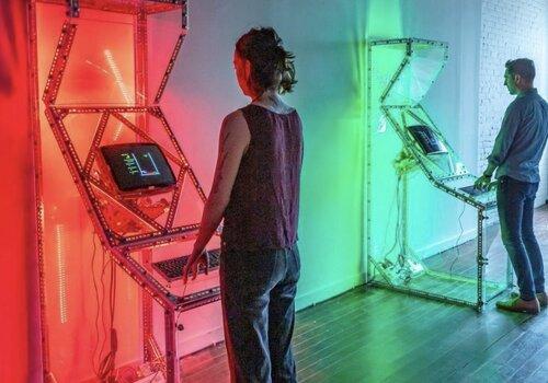 Deux personnes devant des bornes d'arcade. 