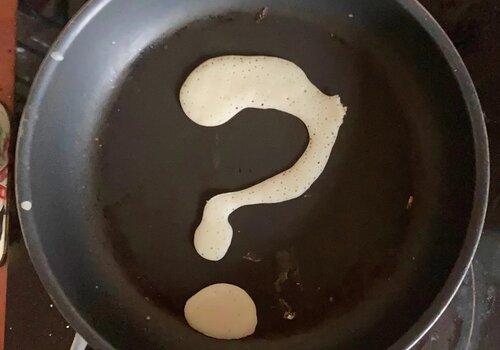 De la pâte à crêpe en forme de point d'interrogation dans une poêleUne poêle 