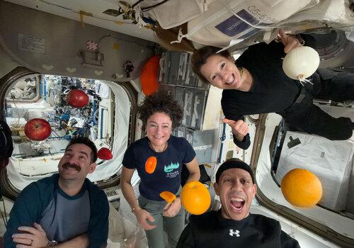 astronautes dans l'iss avec des légumes qui flottent