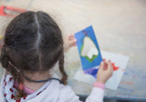 Petite fille de dos en train de réaliser un atelier de pratique artistique