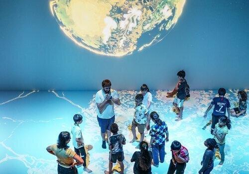 Médiateur et public en salle immersive à Cosmocité
