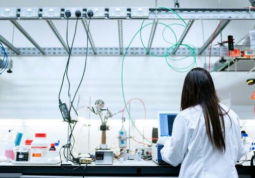 Femme de dos en bouse blanche dans un laboratoire de recherche