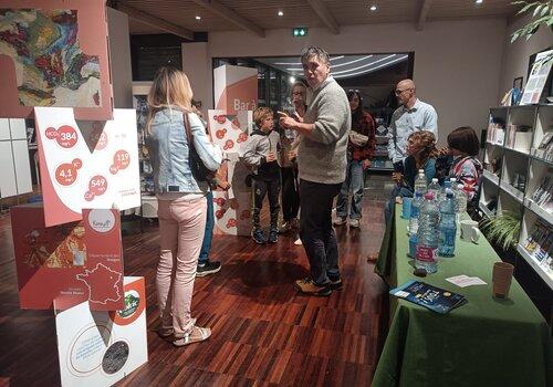 Stand avec quelques participants. A droite une table avec des bouteilles d'eau.