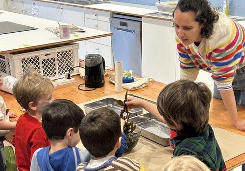 des enfants touchent des algues accompagnés par une médiatrice