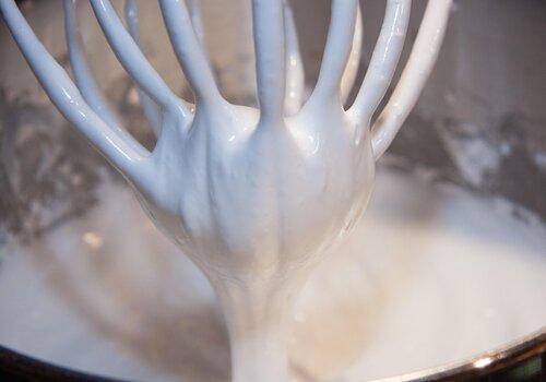 Un batteur dans des blancs d'oeufs en neige
