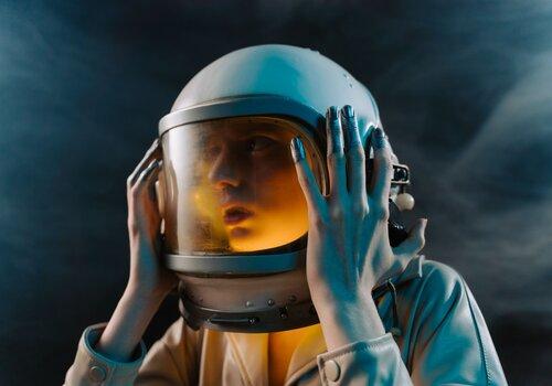  femme spationaute tenant son casque entre ses mains
