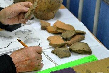 L'archéologue Vladislav Ivanovich Mamontov étudie des céramiques