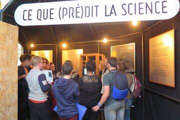 "Ce que prédit la science", photographie d'une partie de l'exposition avec public