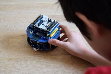 petit robot type rover manipulé par un enfant