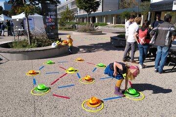 Une photo de la fête de la science 2022 avec un atelier extérieur avec des cerceaux et des chapeaux