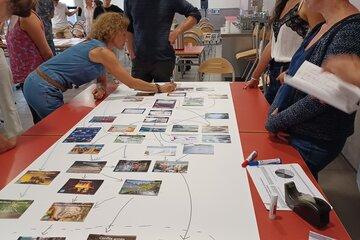 La fresque du climat : des enfants autour d'une table qui placent des étiquettes pour créer des liens entre chacune. 