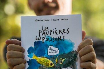Sébastien Moro, vulgarisateur scientifique, tient dans ses mains son ouvrage "Les paupières des poissons. Une épopée scientifique et pleine d'humour à la rencontre des animaux aquatiques", BD publiée aux éditions LA PLAGE.
