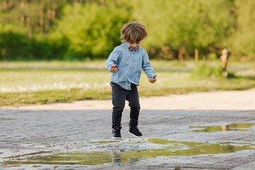 Un enfant joue dans une flaque d'eau