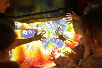 Un bac rempli de sable fin surplombé d’une caméra 3D et d’un vidéoprojecteur qui diffuse en temps réel les courbes de niveaux et des couleurs différentes