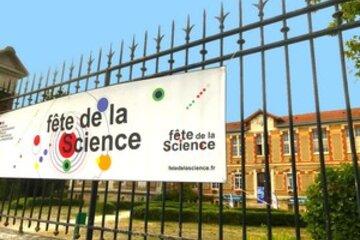 Vue de l'INSPé depuis la rue. Sur la grille est suspendu un caliquot présentant la Fête de la Science.
