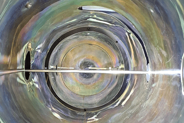 Photo du réacteur de MISTRAL (à l'arrêt ici), qui produit une colonne de plasma pour des études physiques au laboratoire PIIM (CNRS / Aix-Marseille Université). Les couleurs réfléchies par le métal dépendent des dépots de matières et des températures subies par le métal. Les multiples réflexions aident à faire de ce simple tube un très beau spectacle visuel.