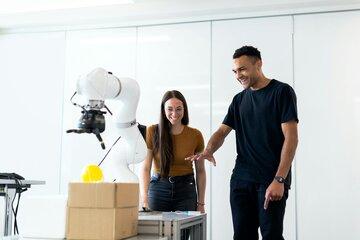 Deux personnes autour d'un bras robotisé