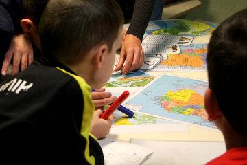 des enfants jouant à un jeu basé sur des cartes géographique