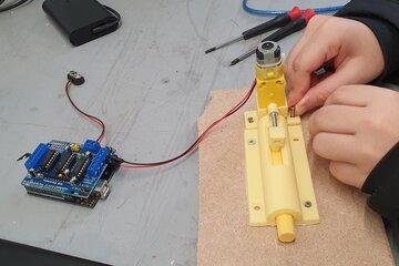 une personnes qui manipule une serrure imprimé en 3d et reliée à une carte arduino