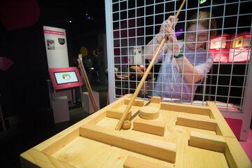 Un ado joue avec un bâton pour sorti r un objet d'un labyrinthe