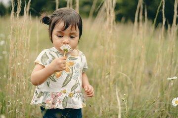 Petite fille sentant une fleur