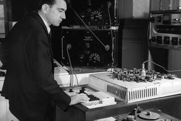 Pierre Schaeffer dans les années 1950, debout devant une table de son