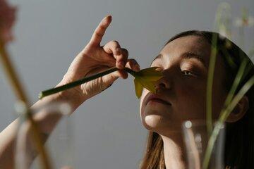 Jeune femme sentant une fleur coupée